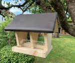 Feeder for garden birds with hinged roof for uncomplicated feeding of the food and weather-protected feeding compartment